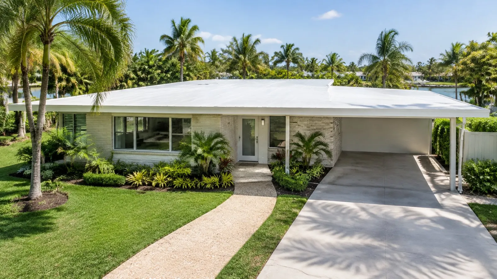 Mid-century Florida home with a new white membrane on its flat roof and carport